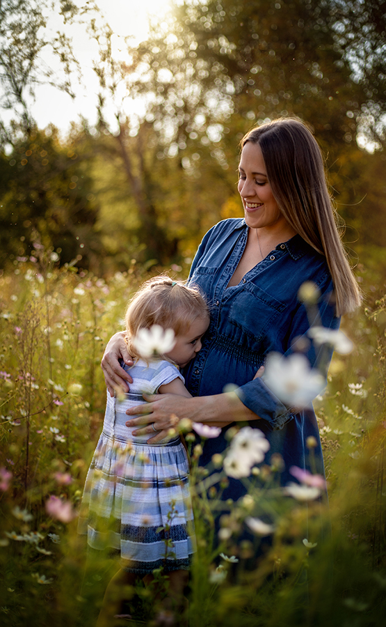 little girl kissing mommys pregnant belly